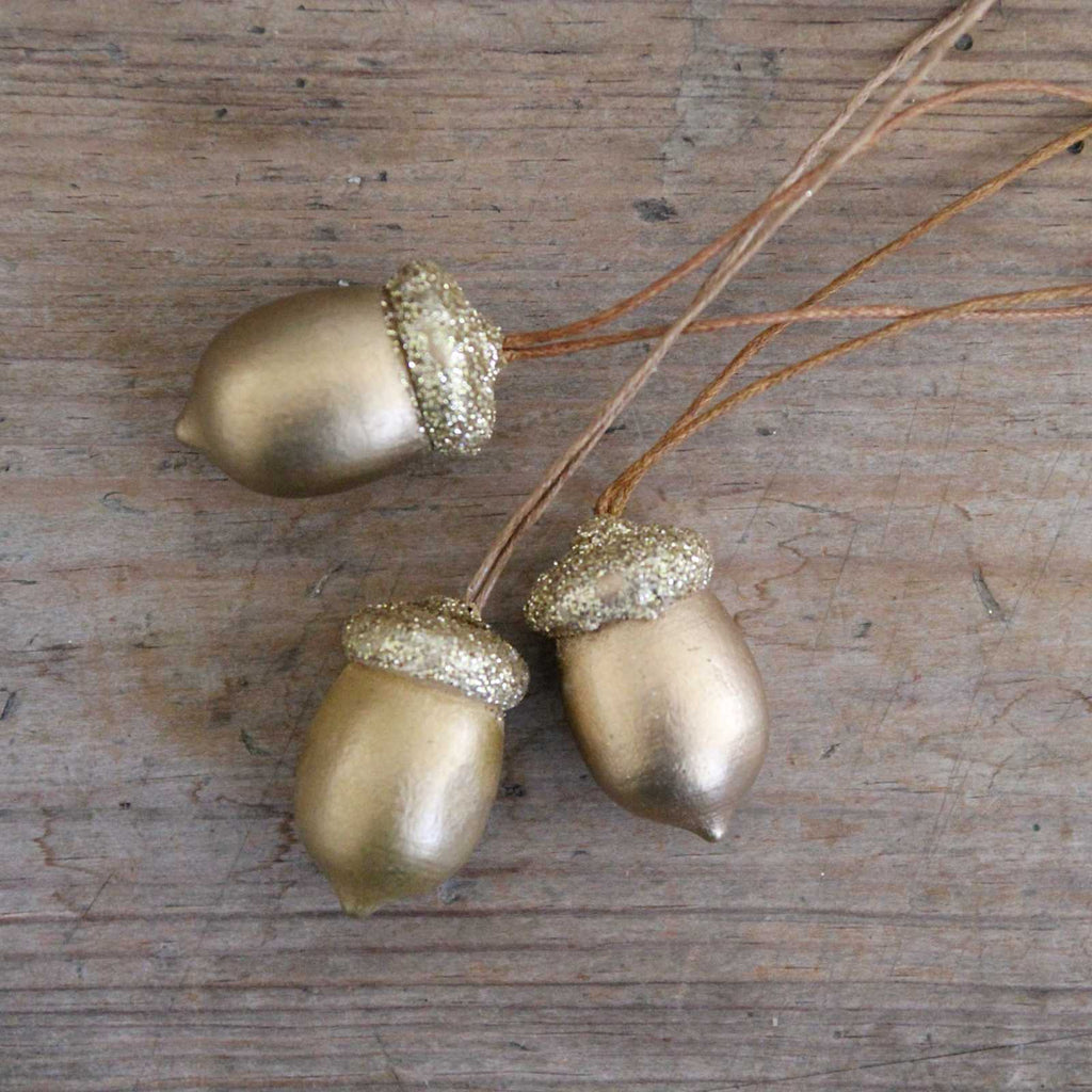 Traditional vintage Christmas decoration - wooden gold acorn with a sparkly gold top