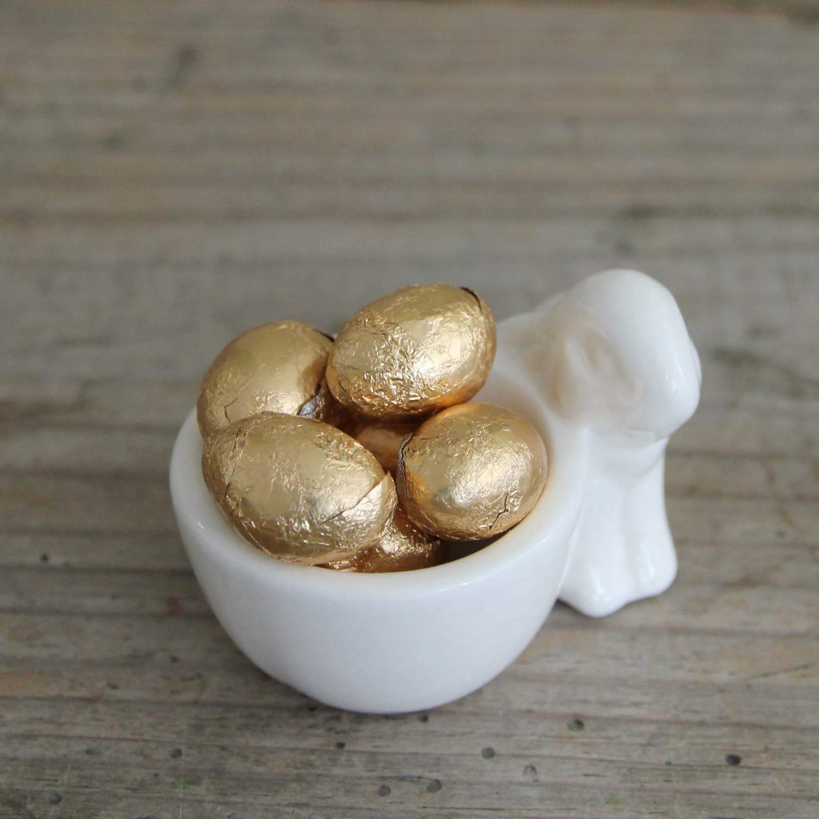 Easter Bunny Rabbit Egg Cup with gold Chocolate Eggs.